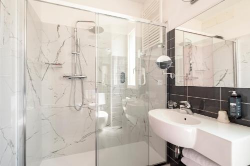 a white bathroom with a shower and a sink at Hotel Cristallo in Rimini