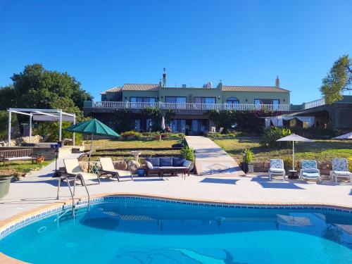 a swimming pool in front of a house at Vista Magica B&B in Santa Bárbara de Nexe