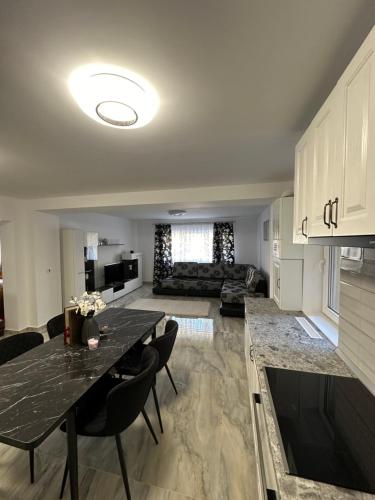 a kitchen and living room with a table and a couch at Enk Residence in Târgovişte