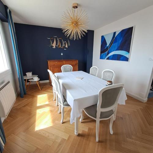 une salle à manger avec une table et des chaises blanches dans l'établissement Rêve bleu, à Royan
