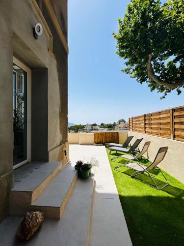 un groupe de chaises assises sur une terrasse dans l'établissement Maisons Détente Jardin, terrasse Vue Mer et Spa Marseille, à Marseille