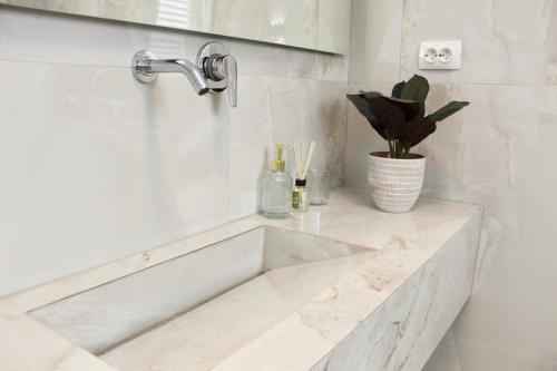 a white bathroom with a sink and a faucet at Luxury Apartment Antoni in Podstrana