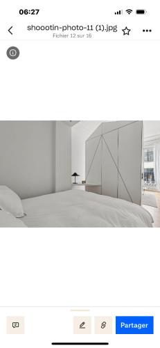 une chambre blanche avec un grand lit dans une pièce dans l'établissement Appartement design au cœur de paris, à Paris