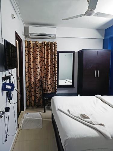 a bedroom with a bed and a window with a television at Delta Inn Madiwala in Bengaluru