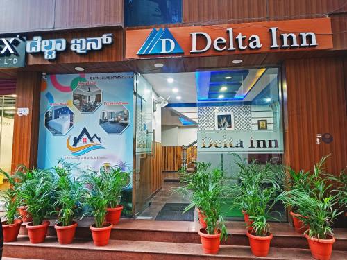 a store front with potted plants in front of it at Delta Inn Madiwala in Bengaluru
