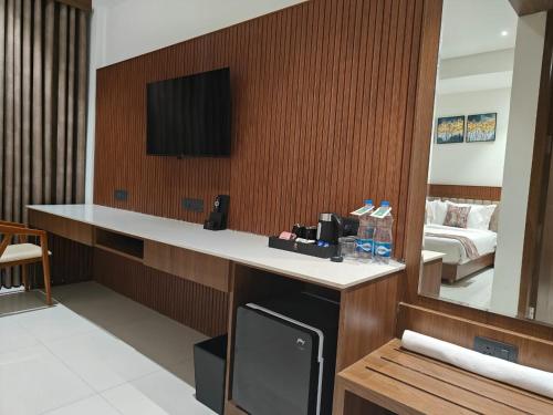 a hotel room with a television and a bed at Kings Kraft Tremezzo Inn, Somnath in Somnath