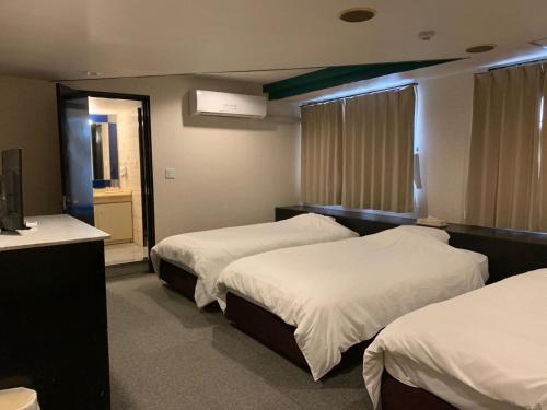 a hotel room with two beds and a mirror at 大阪グランドホテル Osaka Grand Hotel in Osaka