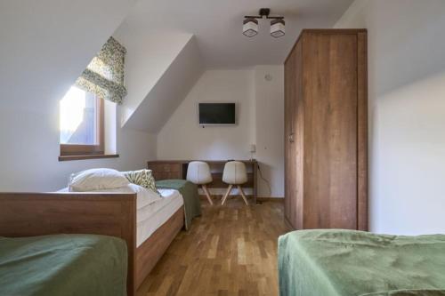 une chambre avec deux lits et une armoire en bois dans l'établissement Apartament Kohutówka, à Bukowina Tatrzańska