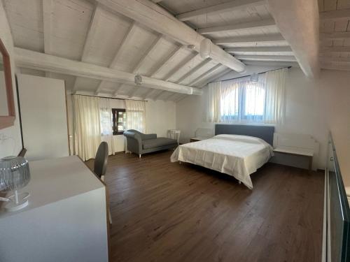 a bedroom with a bed and a couch in it at La Vecchia cantina Guzzardi in Lari