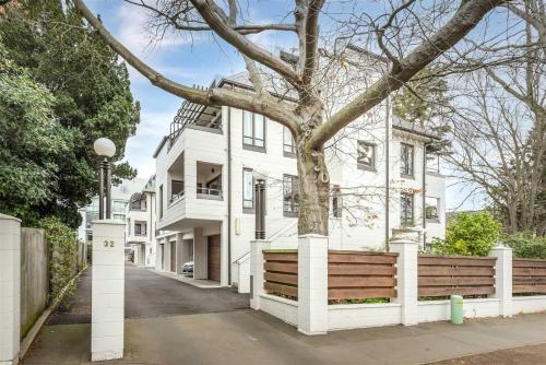 a white house with a tree in front of it at Heart of Christchurch in Christchurch