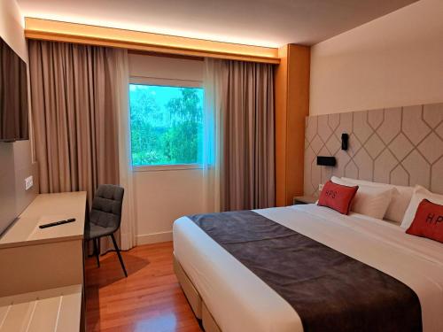 um quarto de hotel com uma cama, uma escrivaninha e uma janela em Hotel Puerta Santander em Santander