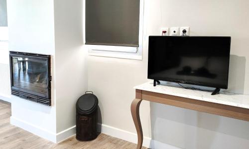 a flat screen tv sitting on a counter next to a television at Joanna Deluxe Apartments in Kynopiástai