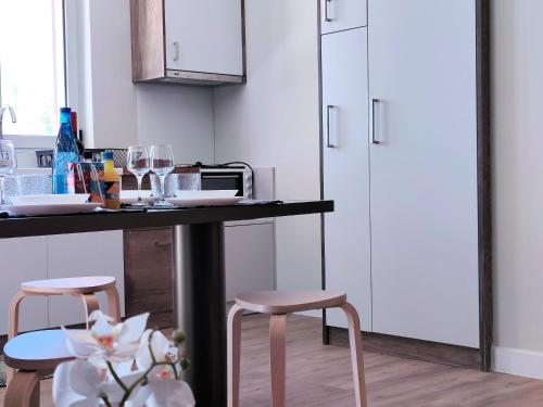 a kitchen with a counter with two stools and a table at Joanna Deluxe Apartments in Kynopiástai