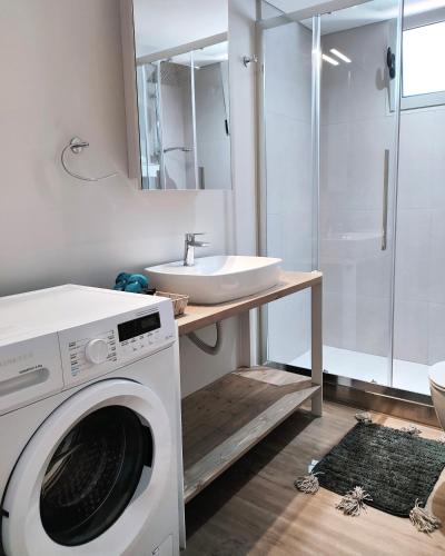 a washing machine in a bathroom with a sink at Joanna Deluxe Apartments in Kynopiástai