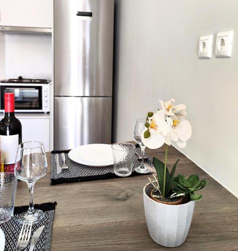 a kitchen with a table with a white flower in a pot at Joanna Deluxe Apartments in Kynopiástai