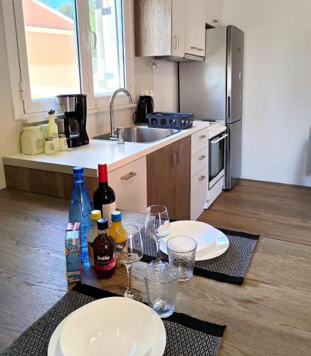a kitchen with a table with plates and wine glasses at Joanna Deluxe Apartments in Kynopiástai