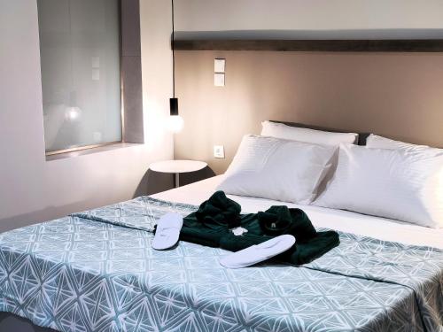 a bed with a robe and shoes on it at Joanna Deluxe Apartments in Kynopiástai