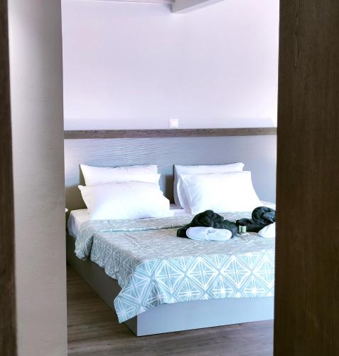 a bedroom with a bed with white sheets and pillows at Joanna Deluxe Apartments in Kynopiástai