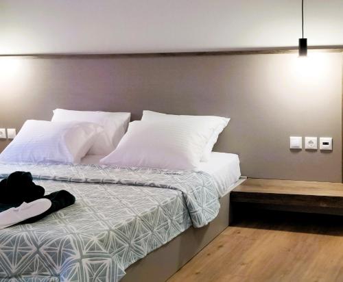 a bedroom with a bed with white sheets and pillows at Joanna Deluxe Apartments in Kynopiástai