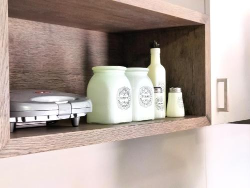a shelf with three white vases and a toy on it at Joanna Deluxe Apartments in Kynopiástai