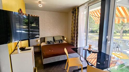 モンペリエにあるStudio Soleil et Verdure - Montpellier Celleneuveのベッド、テーブル、窓が備わる小さな客室です。