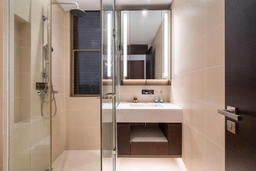 a bathroom with a sink and a shower at Sanya Haitang Bay Muyu Time Seaview Apartment in Sanya