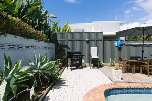 a backyard with a pool and a patio with a table at Miami's Family Getaway Sleeps 10, Pool, Patio, Walk to North Burleigh Beach & Shops in Gold Coast