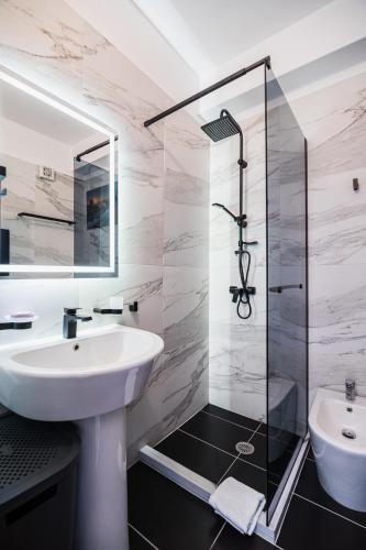 a bathroom with a sink and a shower at Saranda Terraces Exclusive Appartment in Sarandë