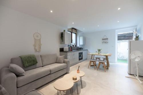 un salon avec un canapé et une table dans l'établissement Appartement entièrement neuf avec terrasse privative !, à Mulhouse
