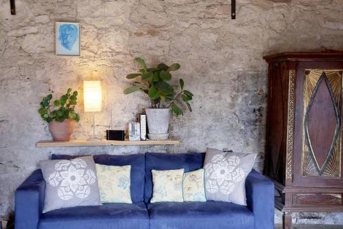a blue couch with pillows in a living room at The Book Shop in Robe