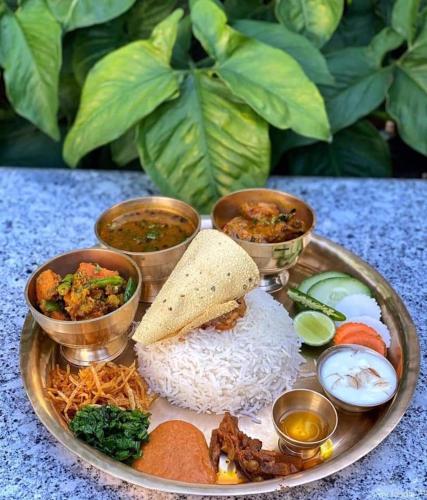 a plate of food with rice and bowls of food at Hotel Royal Inn Nuwakot in Trisūli Bāzār