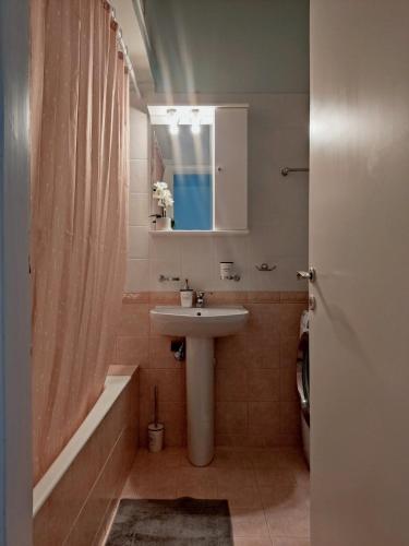 a bathroom with a sink and a shower curtain at Los Laureles A Relaxing Vintage Home in the Heart of Sparta in Sparta