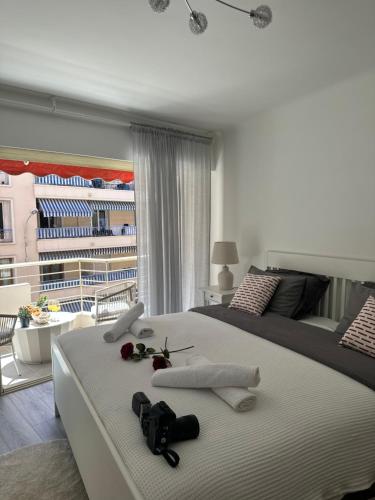 a bedroom with a large white bed with a balcony at T3Appartement de luxe Croisette en face de la plage Martinez 80m2 in Cannes