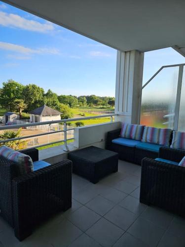 d'un balcon avec des canapés et une vue sur la rivière. dans l'établissement Appartement au golf des fontenelles, à LʼAiguillon-sur-Vie