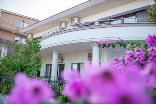 a building with pink flowers in front of it at Ami Apartments in Ulcinj