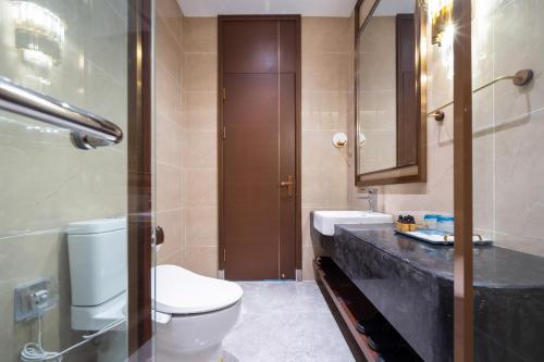 a bathroom with a toilet and a sink at Sanya Haitang Bay Muyu Time Seaview Apartment in Sanya