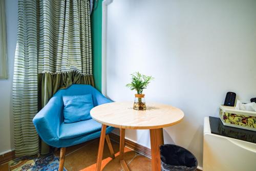 a table and a blue chair in a room at Zhangjiajie Han Exotic Inn in Zhangjiajie