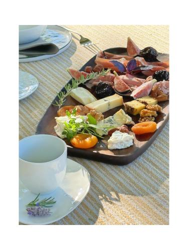 a plate of food on a table next to a cup at Les Jardins de Sitaara in Cucuron