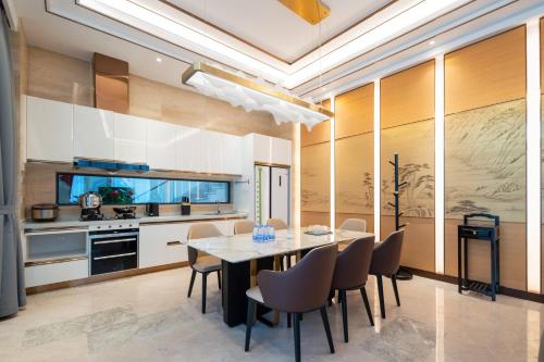 a kitchen and dining room with a table and chairs at Sanya Haitang Bay Muyu Time Seaview Apartment in Sanya