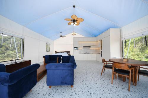 a living room with blue chairs and a table at Villa Casa de Monique in Bogor