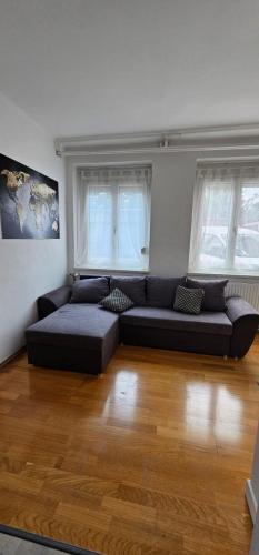 a living room with a couch and two windows at KB Apartment #2 in Zeltweg