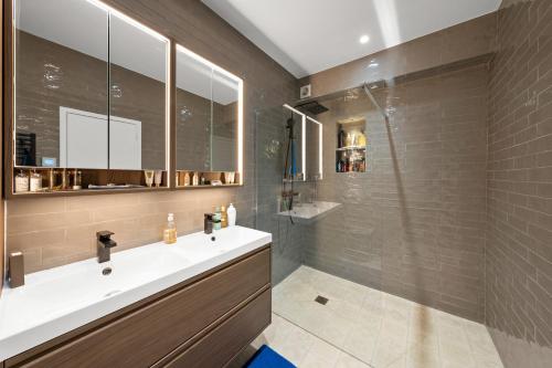 Un baño con lavabo y ducha de cristal. en Riviera Villa, en Mandelieu-la-Napoule
