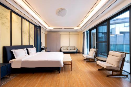 a hotel room with a bed and a chair at Sanya Haitang Bay Muyu Time Seaview Apartment in Sanya