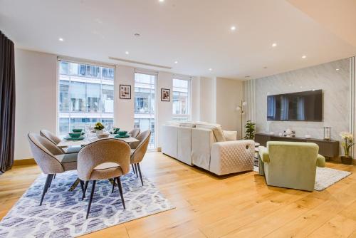 a dining room and living room with a table and chairs at London Paddington Apartment in London