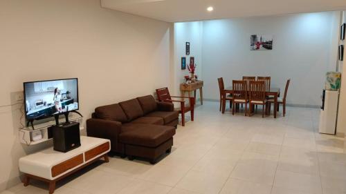 a living room with a couch and a dining room at Villa Bhuvana ciawi bogor by rasya in Ciawi Bogor