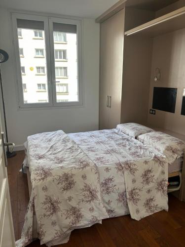 une chambre avec un lit avec une couverture dessus dans l'établissement Appartement cosy vue sur la Seine, à Boulogne-Billancourt