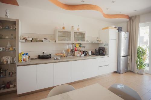 Una cocina con gabinetes blancos y un refrigerador. en B&B Il FIORONE, en Torre Canne