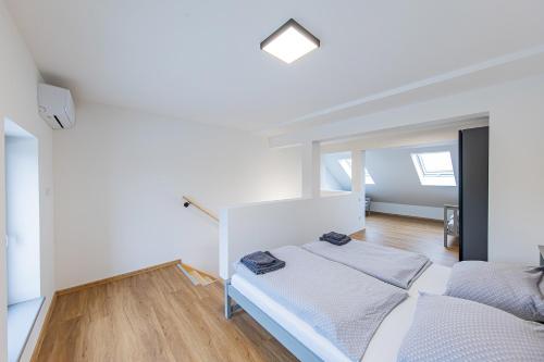 a white bedroom with a bed and a window at Rezidence Novosadská in Olomouc