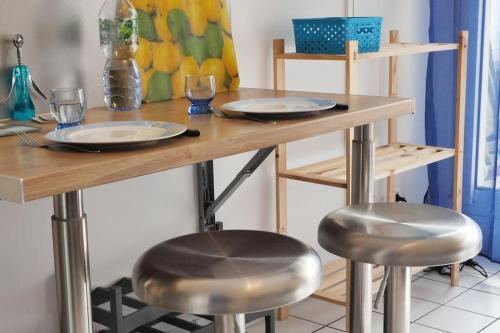 une table avec deux tabourets avec des assiettes et des verres dans l'établissement OPARADI 