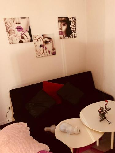 Cette chambre comprend un lit, une table et des photos sur le mur. dans l'établissement Visa pour l image Wellcome la famille et les enfants, à Perpignan